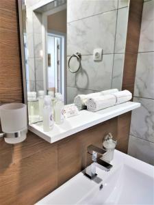 a bathroom with a sink and a mirror at ROCAS Hotel in Orhei