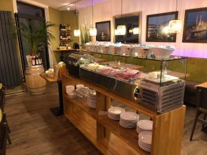 a restaurant with a counter with plates and food at Burghotel Homberg in Homberg