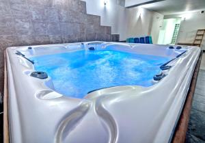 a large bath tub with blue water in it at Apartament Górski - SPA pod Nosalem in Zakopane