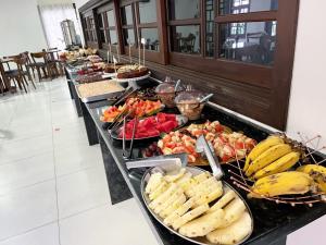 a buffet line with many different types of food at Pousada Battistella in Garopaba