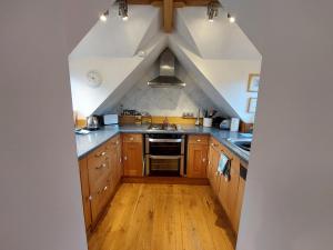 an attic kitchen with wooden cabinets and wooden floors at The Tower our scottish castle in miniature in Acharacle