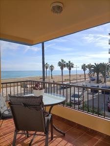 a balcony with a table and chairs and a view of the beach at Apartamento Laurel in Peñíscola