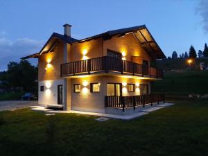 a large house with lights on it at night at Noor in Vatra Dornei