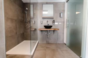 a bathroom with a glass shower with a sink at Altstadt Hotel Self Check-In in Würzburg +62 photos