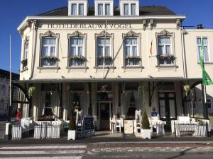 a white building with a sign on the front of it at Hotel de Blauwe Vogel in Bergen op Zoom