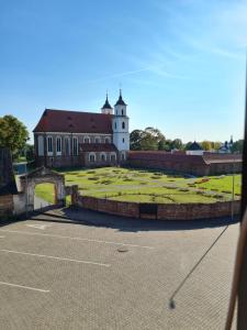 - une vue sur un bâtiment avec un champ et un château dans l'établissement Svečių namai Žara, à Tytuvėnai