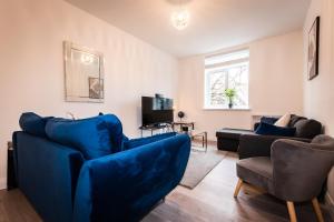 un soggiorno con divano blu e sedie di BEST PRICE - Superb Southampton City Apartments, Single Beds or King Size & Sofabed - AMAZING location close to MAYFLOWER THEATRE FREE PARKING a Southampton