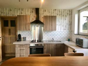 a kitchen with a sink and a stove top oven at Gîte aux prés de mon père in Vresse-sur-Semois