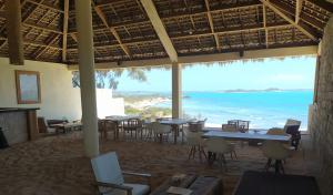 um restaurante com mesas e cadeiras e vista para o oceano em Mazava Loha Resort em Antsiranana