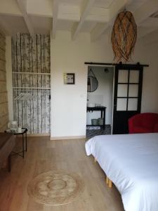 a bedroom with a white bed and a red chair at Chambre d'hôtes Le Cocon des Champs in Buzet-sur-Baïse +9 photos