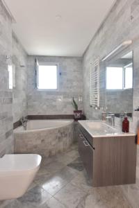 a bathroom with a tub and a sink and a bath tub at Select Collection Hammam Sousse appartments in Sousse +43 photos