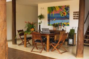 a dining room with a table with chairs and a laptop at Mar Ilha Pousada in Itacaré