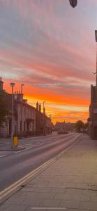 an empty city street with a sunset in the background at The Banks Of Ury in Inverurie