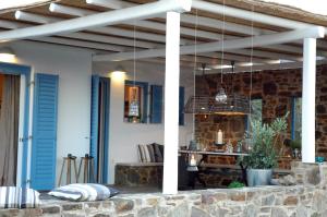 a patio with awning and a brick wall at Chez Semiramis Aegean Pearl House for 8 persons 5'min from the beach in Serifos Chora