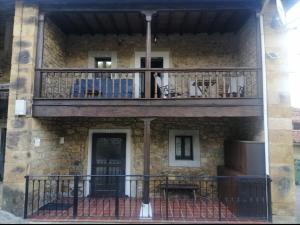 - Balcón de un edificio de piedra con porche en Casa rural apartamentos Ángel Inguanzo Cabrales, en Inguanzo