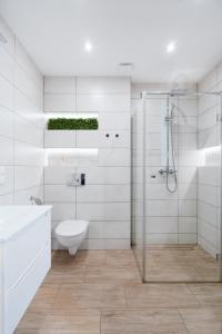 un bagno bianco con wc e doccia di Apartament Na Borach II SPA a Szczyrk Altre 14 foto