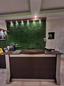 una pared verde en una habitación con escritorio en Asha Guest House en Amritsar