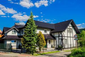 a white house with a black roof at Dom daleko od domu in Krościenko