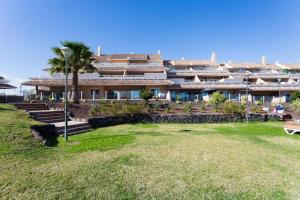 ein großes Gebäude mit einer Rasenfläche davor in der Unterkunft DeLuxe Apt. 110qm+Terrasse 60qm Pool WIFI Golf Yachthafen in San Miguel de Abona