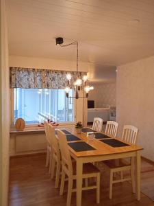 comedor con mesa de madera y sillas en Omakotitalo keskustan lähellä, en Joensuu