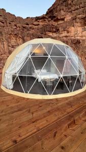 a glass dome with a table inside of it at Wadi Rum Bedouin Camp in Wadi Rum