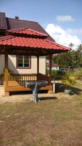 a bench in front of a house with a gazebo at D'Ombak Homestay Pantai Baru in Bachok