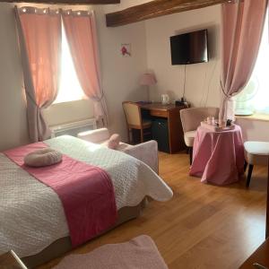 - une chambre avec un lit, un bureau et une table dans l'établissement Auberge Du Cheval Blanc, à Beaumont-Pied-de-Boeuf