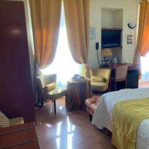 a hotel room with a bed and a table and chairs at Auberge Du Cheval Blanc in Beaumont-Pied-de-Boeuf