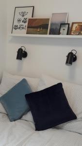 a bed with a blue pillow and two lights above it at LILIOM Apartment with FREE PARKING space in Budapest