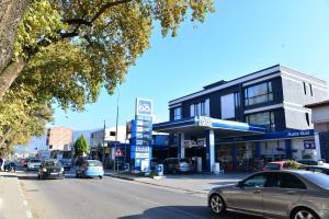 een stadsstraat met auto's die voor een gebouw geparkeerd staan bij Admiral Hotel in Elbasan