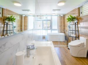 un bagno con vasca, lavandino e WC di Revel Villa a Puli Altre 35 foto