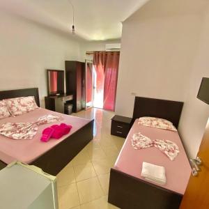 a room with two beds with bows on them at Vila Llaka in Himare +28 photos