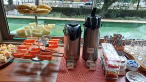 a table with a juicer and slices of fruit and cheese at Hotel York in Petrópolis