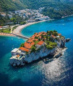 an island in the water with a house on it at Apartmani Dačo in Sveti Stefan