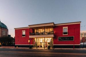 un edificio rojo en una calle con una tienda en Church Street Inn, en Natchitoches