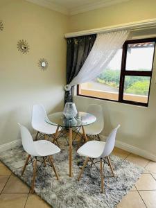 a dining room with a table and chairs and a window at Ocean View Villas D3 in Port Edward +17 photos