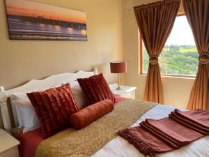 a bedroom with a bed with pillows and a window at Ocean View Villas D3 in Port Edward