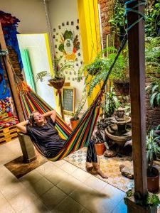 a woman laying in a hammock in a room at La Casa de Adry in Cali