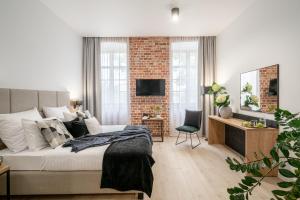 a bedroom with a bed and a brick wall at AbsyntApartments 24 Rynek Wrocław in Wrocław