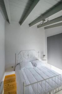 1 dormitorio con 1 cama blanca en una habitación blanca en Yvonne's Stone House, en Arachova