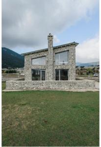 a stone house with large windows on a field at Yvonne's Stone House in Arachova