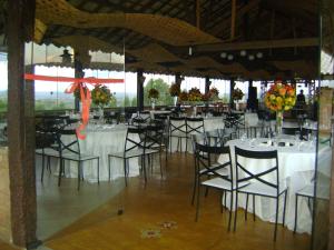 ein Zimmer mit Tischen und Stühlen mit weißen Tischdecken in der Unterkunft Pousada Serra Azul in Tiradentes