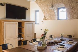 drewniany stół z krzesłami i telewizor na ścianie w obiekcie Corte Mira w mieście Lonato