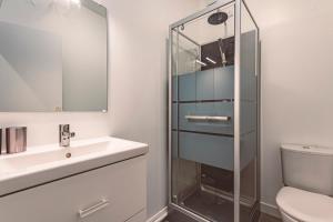 a bathroom with a sink and a glass shower at Plancy Beds St-Quentin in Saint-Quentin