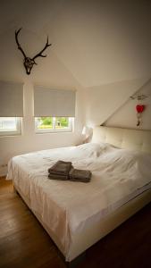 a bedroom with a white bed with two bags on it at Ferienhaus MountFrosch mit Sauna und Naturpool in Monschau