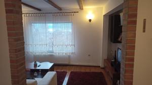 a living room with a couch and a window at Panoramic Chalet in Vişeu de Sus