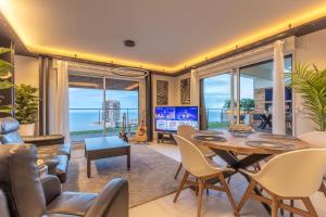 a living room with a table and chairs and a television at Monaco view, pool, garage, 100 m2 terrace in Beausoleil
