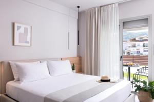 奧林匹亞達的住宿－Afros Suites，一间带白色床的卧室和一个阳台