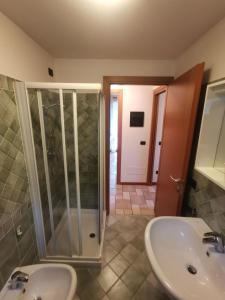 a bathroom with a glass shower and a sink at APPARTAMENTO CORTAIOLO HOUSE in Vione