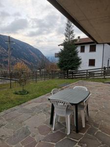 a table and two chairs on a stone patio at APPARTAMENTO CORTAIOLO HOUSE in Vione +4 photos